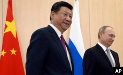 FILE - Russian President Vladimir Putin, right, and Chinese President Xi Jinping smile prior their talks during the summit in Ufa, Russia, July 8, 2015.