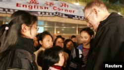 FILE - Young Chinese students practise their English with a foreigner at an open-air English Corner in Shanghai March 25, 2005. China, the world's most populous nation, has become the world's largest market for English learning. (REUTERS/Claro Cortes IV)