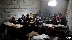 Azez yakınlarındaki bir köy okulunda yüz maskesiyle eğitimlerine devam etmek zorunda kalan Suriyeli çocuklar