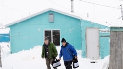 Census bureau director Steven Dillingham, right, walks alongside Census worker Tim Metzger after conducting the first enumeration of the 2020 Census Tuesday, Jan. 21, 2020, in Toksook Bay, Alaska.