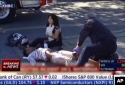 A first responder attends to a person outside a Southern California social services center in San Bernardino, where authorities said multiple people were shot Wednesday, Dec. 2, 2015.