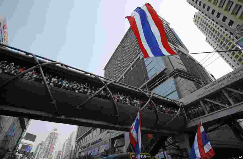 Hundreds of supporters wait for a glimpse of anti-government protest leader Suthep Thaugsuban during a march through central Bangkok, Thailand.