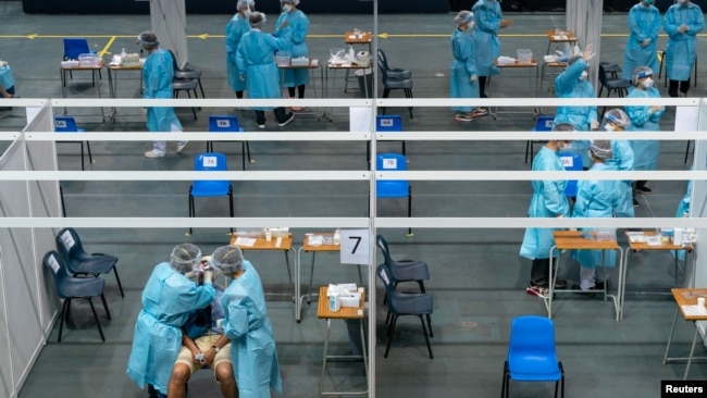 医护人员在香港的一个社区检测中心给市民进行新冠病毒检测。（2020年9月1日）