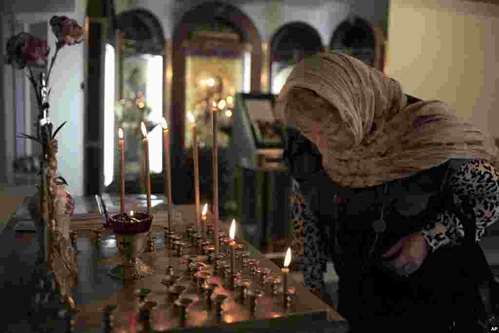 26日在多莫杰多沃国际机场的一个教堂人们点燃蜡烛悼念受难死亡人士