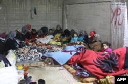 FILE - Families take shelter in basements in the Kurdish town of Jandairis near the Syrian-Turkish border, west of the city of Afrin, Jan. 26, 2018.