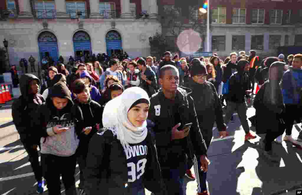 Hundreds of students walk out of Midwood High School as part of a nationwide protest against gun violence, March 14, 2018, in the Brooklyn borough of New York. 
