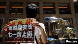 香港一名抗議者舉牌反對港版國安法，號召七一遊行。（2020年6月30日）