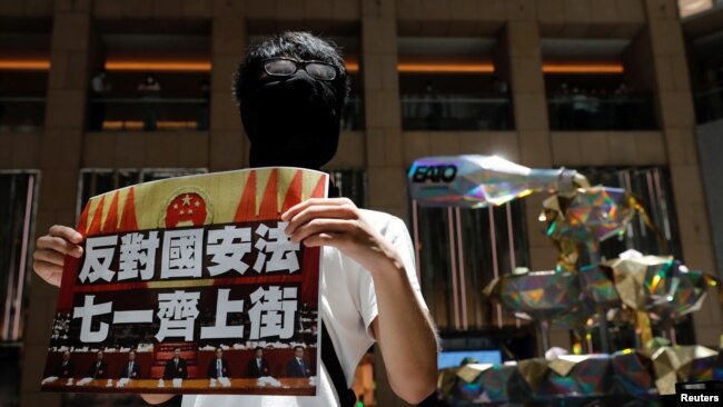 香港一名抗议者举牌反对港版国安法，号召七一游行。（2020年6月30日）