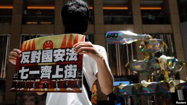 香港一名抗议者举牌反对港版国安法，号召七一游行。（2020年6月30日）