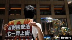 香港一名抗議者舉牌反對港版國安法，號召七一遊行。（2020年6月30日）