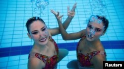 FILE - Brazil's synchronized swimmers Luisa Borges (R) and Maria Eduarda Miccuci pose for a photograph after a training session at the Rio Olympic Park in Rio de Janeiro, Brazil, April 7, 2016.