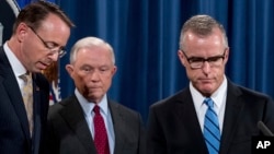 FBI Acting Director Andrew McCabe, right, accompanied by Attorney General Jeff Sessions, second from left, Deputy Attorney General Rod Rosenstein, takes the podium at a news conference at the Department of Justice, July 20, 2017, in Washington.