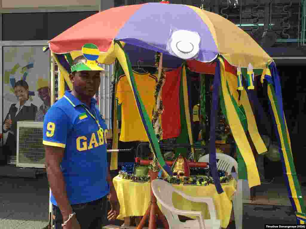 Un vendeur se promène dans les rues de Port-Gentil avant le match du groupe D, au Gabon, le 16 janvier 2017. (VOA/ Timothée Donangmaye)