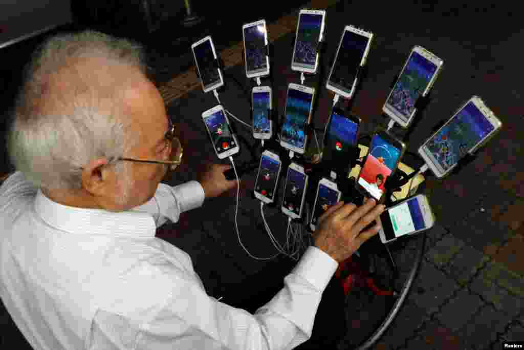 타이완 뉴타이페이에서 &quot;포켓몬 할아버지&quot;라고 알려진 70세의 첸 산 위안 씨가 15개의 휴대폰으로 닌텐도에서 출시한 &#39;포켓몬 고&#39; 게임을 하고 있다.