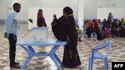 Seorang perempuan memberikan suaranya dalam pemilihan parlemen di Somalia, di sebuah tempat pemungutan suara di Mogadishu (6/12).