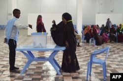 A woman casts her vote during Somalia's parliament election, at a polling station in Mogadishu, Somalia, Dec. 6, 2016. An electoral body on Wednesday annulled the results in 11 races of the poll, citing irregularities.
