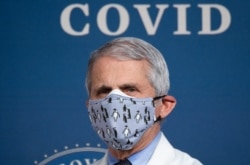 (FILES) In this file photo White House Chief Medical Adviser on Covid-19 Dr. Anthony Fauci listens as US President Joe Biden (out of frame) speaks about the 50 million doses of the Covid-19 vaccine shot administered in the US during an event commemorating