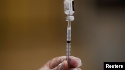На фото: медсестра заповнює шприц вакциною виробництва Pfizer