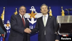 South Korean Defense Minister Kim Kwan-jin (R) shakes hands with U.S. Defense Secretary Leon Panetta during a joint news conference in Seoul.