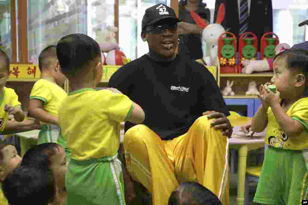 북한을 방문 중인 미국프로농구(NBA) 스타 출신 데니스 로드먼이 15일 평양의 애육원(고아원)을 방문해 어린 아이들과 함께 앉아 있다.