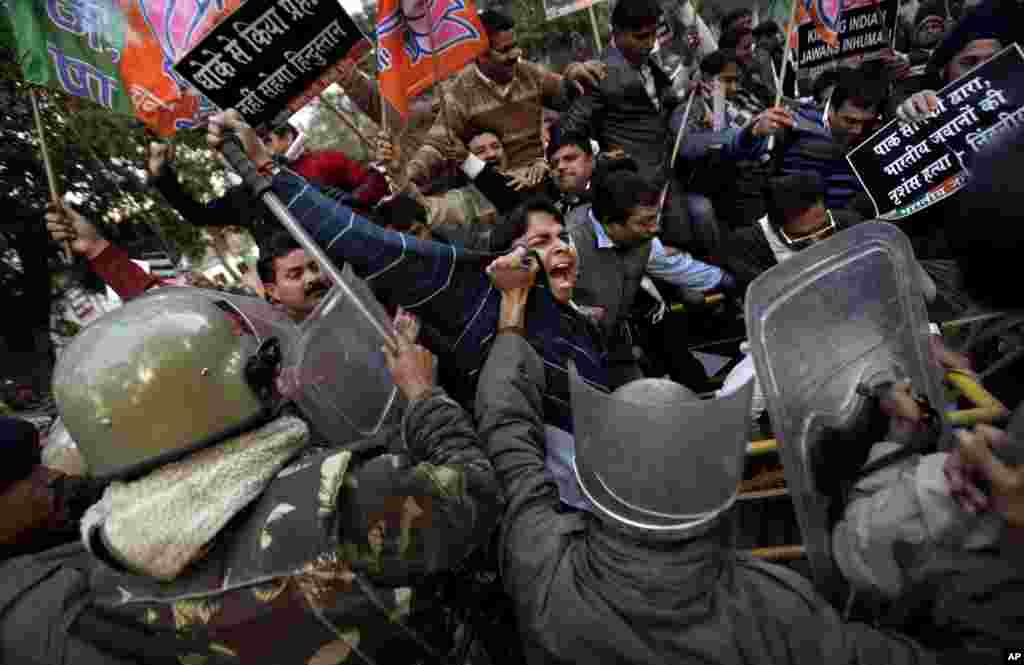 Supporters of India's main opposition BJP scuffle with Indian policemen as they try to scale a police barricade during a protest against Pakistan in New Delhi, India, January 9, 2013. 