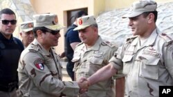 In this picture provided by the office of the Egyptian Presidency, Egyptian President Abdel Fattah el-Sisi, second left, greets members of the Egyptian armed forces in Northern Sinai, Egypt, July 4, 2015.