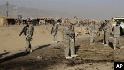 US soldiers inspect the site of suicide attack in Kandahar, Afghanistan, Saturday, Dec. 18, 2010.