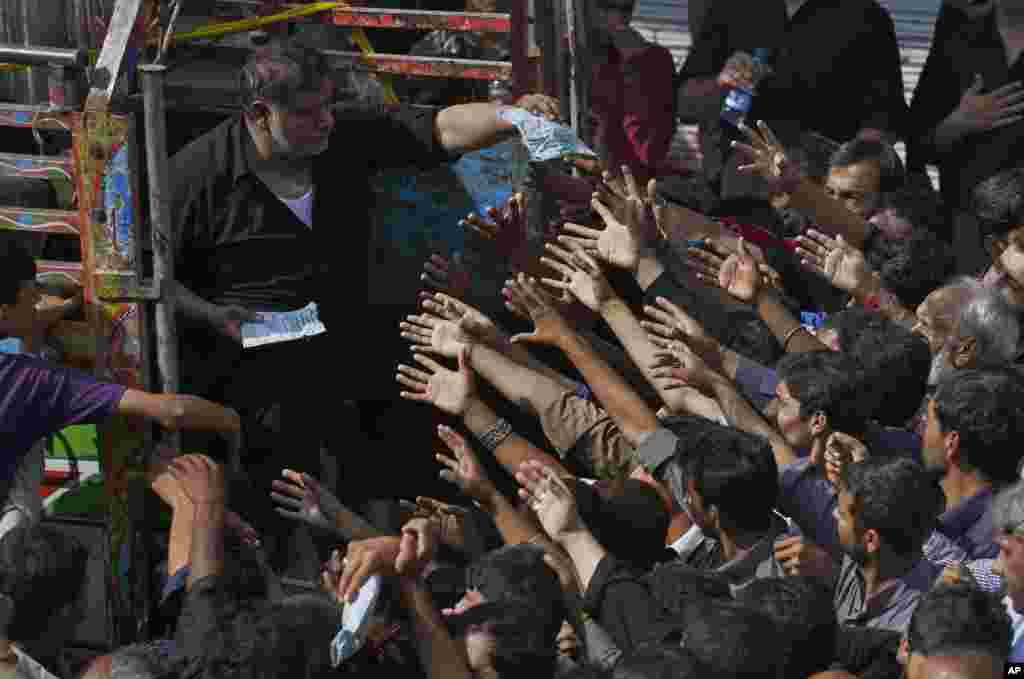 Shi&#39;ite Muslims jostle to get free food donated by businessmen during a procession to mark Ashoura in Rawalpindi, Pakistan.