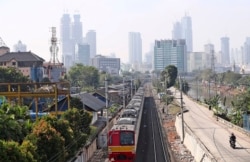Sebuah kereta api bergerak di jalurnya di tengah polusi kota Jakarta, Kamis, 16 September 2021.