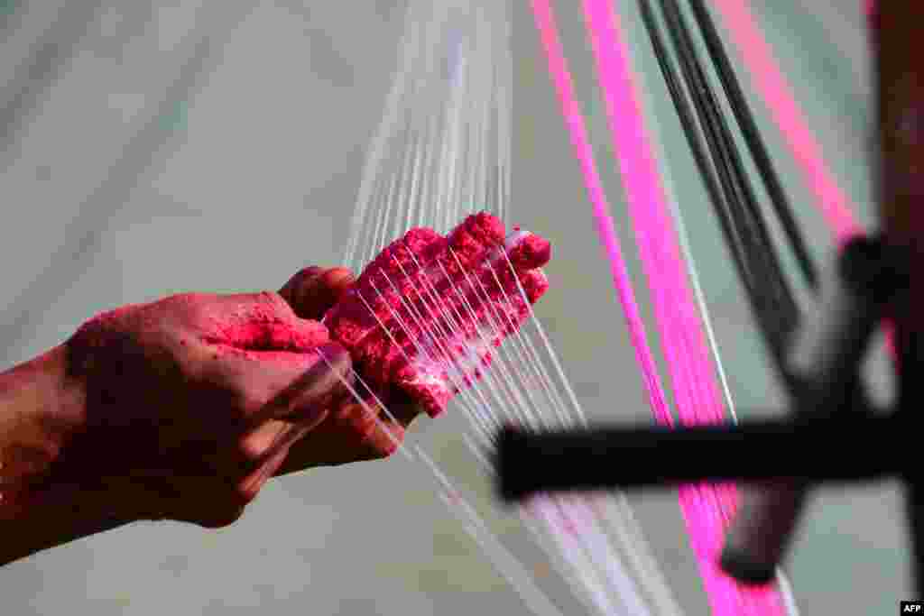 A worker prepares strings coated with powdered glass used for flying kites ahead of &#39;Uttarayan&#39; festival in Ahmedabad, India.