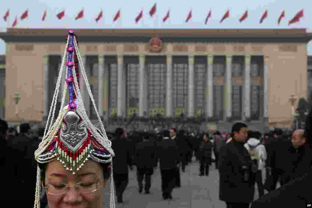 A delegate wearing an ethnic minority costume arrives at the Great Hall of the People where a plenary session of the National People's Congress is held in Beijing, March 15, 2013. 