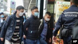 Urednika "Stand News" Patrika Lama, drugog slijeva, uhapsili su policajci u Hong Kongu, srijeda, 29. decembra 2021.