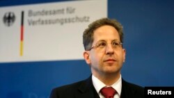 FILE - President of Germany's intelligence agency Verfassungsschutz Hans-Georg Maassen listens during a visit by German Interior Minister Thomas de Maiziere at the Federal Office for the Protection of the Constitution in Cologne.