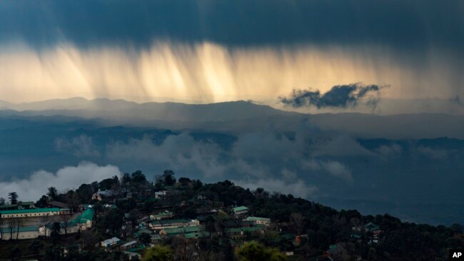 Streaks of rain and dark clouds are seen over the Kangra Valley in Dharmsala, India, Saturday, Feb. 29, 2020. The region saw heavy rains and thunderstorm Saturday morning. (AP Photo/Ashwini Bhatia)