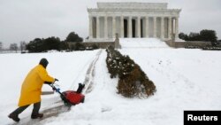 13일 미국 동북부에 눈폭풍이 불어닥친 가운데, 워싱턴 링컨기념관 앞에서 관리 인력이 눈을 치우고 있다.