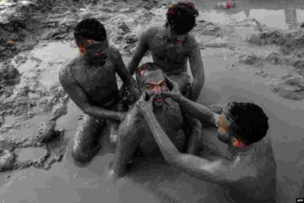 Palestinians cover themselves with Dead Sea mud, on the northwestern shore of the Dead Sea, in the West Bank, south of Palestinian city of Jericho on August 23, 2018 during the Eid al-Adha holiday.