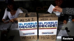 A woman casts her vote during an unofficial plebiscite against Venezuela's President Nicolas Maduro's government and his plan to rewrite the constitution, in Caracas, Venezuela, July 16, 2017.