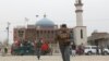 Afghan policemen patrol in front of the Baqir ul Olum mosque on Nov. 21, 2016. Dozens were killed and injured after a suicide bomb attack. 