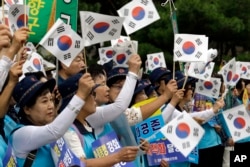 South Koreans wave their national flags during a rally to wish for the successful inter-Korean summit near the presidential Blue House in Seoul, Tuesday, Sept. 18, 2018.
