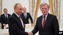 El presidente de Rusia, Vladimir Putin, (izquierda) saluda al asesor de Seguridad Nacional de EE.UU., John Bolton, durante una reunión en el Kremlin en Moscú, el miércoles, 27 de junio de 2018.