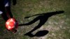 The shadow of a boy controlling a soccer ball is cast on a grassy area on the Barra de Tijuca beach while playing 'altinho' in Rio de Janeiro, Brazil, June 2, 2014. 