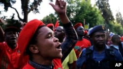 Members of the Economic Freedom Fighters (EFF) party sing during their march for economic reform outside the Johannesburg Stock Exchange, Oct. 27, 2015.