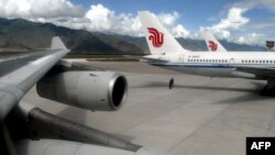 Pesawat dari maskapai Air China tampak bersandar pada landasan Bandara Gongga di Lhasa, Tibet, pada foto yang diambil pada 19 Agustus 2004. Sejumlah maskapai di Asia Pasifik mengumumkan komitmennya untuk mencapai emisi nol bersih pada 2050. (Foto: AFP/Peter Parks)