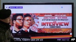 A South Korean army soldier walks near a TV screen showing an advertisement of Sony Picture's "The Interview," at the Seoul Railway Station in Seoul, South Korea, Monday, Dec. 22, 2014. 