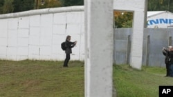 Visitors take photos from both sides of the former East/West German border wall in Moedlareuth, Germany, 3 Oct 2008 (file photo)