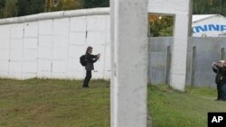 Visitors take photos from both sides of the former East/West German border wall in Moedlareuth, Germany, 3 Oct 2008 (file photo)