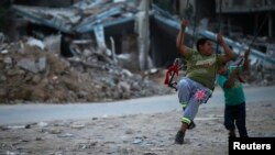 کودکان فلسطینی در نزدیک خانه هایی که توسط اسرائیل ویران شده تاب بازی می کنند. بیت حنون، ۱۳ اکتبر ۲۰۱۴ 