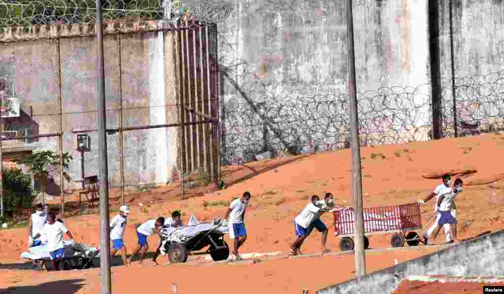 Para narapidana mengangkut maya-mayat setelah terjadinya kerusuhan di penjara di Natal, negara bagian Rio Grande do Norto, Brazil, 15 Januari 2017. &nbsp;