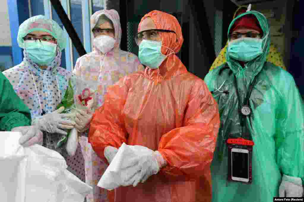 Medical workers wearing disposable raincoats as their protective suits to serve patients are pictured amid the spread of coronavirus disease (COVID-19) outbreak at a local health center in Aceh, Indonesia, April 6, 2020 in this photo taken by Antara Foto.