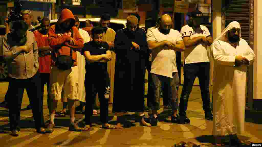 Des hommes prient après qu'un véhicule ait heurté des piétons près d'une mosquée à Londres, le 19 juin 2017.